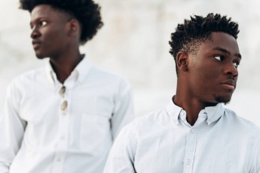 İki modaya uygun siyah adam, beyaz gömlekli Afro-Amerikan erkek modellerin moda portresi, açık havada tebeşir dağları ve kayaların arka planına karşı