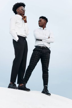 İki Afrikalı Amerikalı, dağın zirvesinde, kayalara tırmanıyor, iş adamı başarısı, dağın zirvesinde yürüyüş, kazanan lider konsepti.