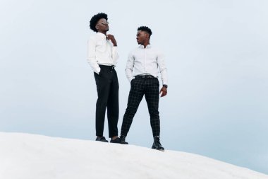 İki Afrikalı Amerikalı, dağın zirvesinde, kayalara tırmanıyor, iş adamı başarısı, dağın zirvesinde yürüyüş, kazanan lider konsepti.