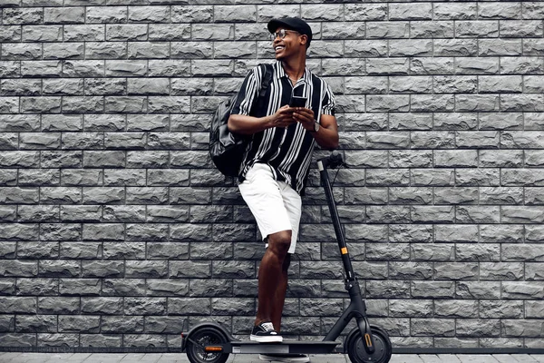 Hombre Afroamericano Con Scooter Teléfono Sus Manos Contra Una Pared — Foto de Stock