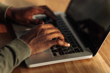 Eller dizüstü bilgisayarda daktilo ediyor. Yan görünüş. İnternet üzerinden iş araması. İnternet işi. İnternetten alışveriş. uzaklık öğrenme