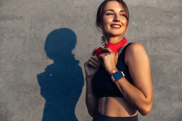 Mooie Sportieve Fitnessvrouw Sportkleding Hoofdtelefoon Buiten Tegen Achtergrond Van Een — Stockfoto