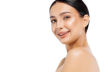 Dişli, gülümseyen genç bir kadın, parlak, mükemmel bir yüz, çıplak omuzlar, beyaz arka plan, kozmetoloji, dermatoloji, diş ve cilt bakımı, güzellik stüdyosu portresi doğru bakıyor