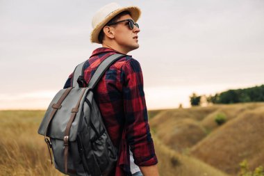 Bir adam dağın tepesinde oturur ve doğanın güzel manzarasının tadını çıkarır. Bir turist uçurumun kenarında oturur ve sisli bir tepeye bakar. Seyahat ve aktif yaşam tarzı kavramı