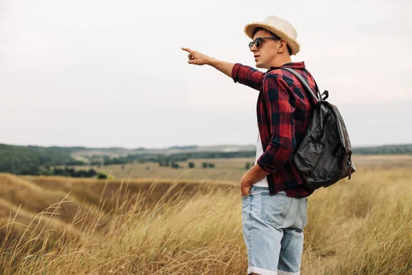 가방을 남자가 여름날걸어 다닌다 젊은이들은 시골길을 야외에서 모자와 선글라스를 — 스톡 사진