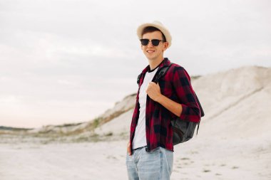 Sırt çantalı gezgin dağlarda yürüyüş yapıyor. Adam yaya olarak yüksek dağlara tırmanıyor. Açık hava aktiviteleri, dağcılık. Seyahat, yaşam tarzı, başarı kavramı