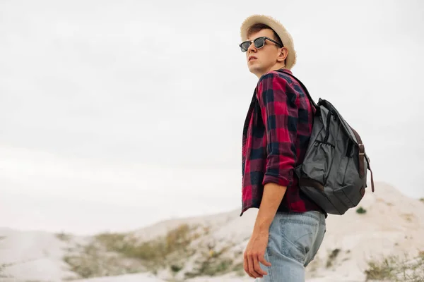 속에서의 가방을 젊은이가 모래투성이의 바위산을걸어 다닌다 산속을 걸어서 야외로 여행하는 — 스톡 사진