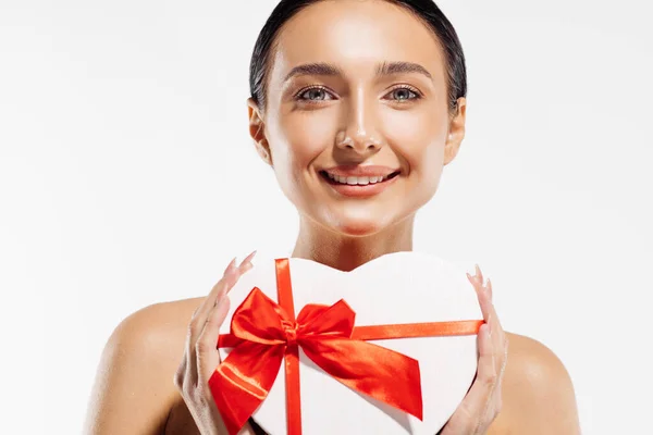 一个快乐的年轻女子拿着一个白色背景的心形红色礼品盒的画像 圣诞照片 情人节 母亲节 — 图库照片