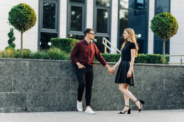 Dışarıda romantik genç bir çift. Sevgililer Günü arifesinde el ele tutuşan bir erkek ve bir kadın birlikte hoş vakit geçirirler. Sevgililer Günü 'nde iki aşık sarılıp öpüşür..