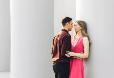 Güzel romantik bir çift, açık havada, elbiseli çekici genç bir kadın ve yakışıklı bir erkek sarılıp birbirlerine bakıyorlar. Sevgililer Günün kutlu olsun.