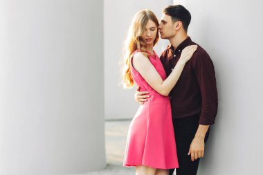 Güzel romantik bir çift, açık havada, elbiseli çekici genç bir kadın ve yakışıklı bir erkek sarılıp birbirlerine bakıyorlar. Sevgililer Günün kutlu olsun.