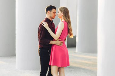 Güzel romantik bir çift, açık havada, elbiseli çekici genç bir kadın ve yakışıklı bir erkek sarılıp birbirlerine bakıyorlar. Sevgililer Günün kutlu olsun.