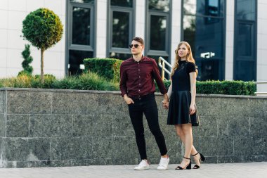 Dışarıda romantik genç bir çift. Sevgililer Günü arifesinde el ele tutuşan bir erkek ve bir kadın birlikte hoş vakit geçirirler. Sevgililer Günü 'nde iki aşık sarılıp öpüşür..