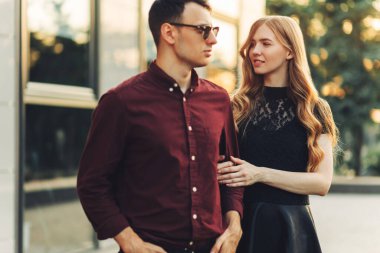 Güzel romantik bir çift, açık havada, elbiseli çekici genç bir kadın ve yakışıklı bir erkek sarılıp birbirlerine bakıyorlar. Sevgililer Günün kutlu olsun.