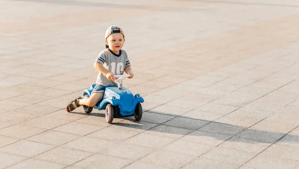小男孩在公园里骑着玩具车 快乐的孩子在阳光灿烂的夏天开车外出 在温暖的夏日与孩子们一起进行的童年 娱乐和户外活动的概念 — 图库照片