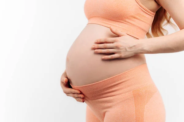白い背景にお腹に触れた妊婦のクローズアップ 赤ちゃんを期待している女性 大きな腹を持つ幸せな妊婦 準備と期待の概念 — ストック写真
