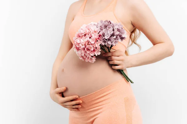 Krásná Těhotná Žena Květinami Drží Ruce Břiše Bílém Pozadí Mladá — Stock fotografie