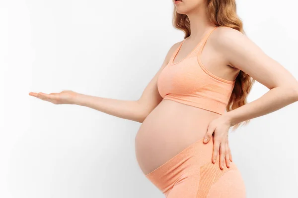 妊娠中の女性は白い背景で胃を握っています 準備と期待の概念 クローズアップ 妊娠の美しい柔らかい気分の写真 — ストック写真