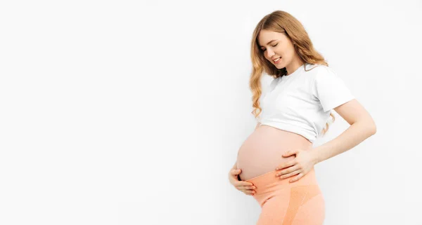 妊娠中の幸せな美しい女性は彼女の腹に触れる 妊娠中のお母さんはお腹を愛撫し 笑顔を閉じています 健康的な妊娠の概念 隔離された白い背景の妊婦 — ストック写真