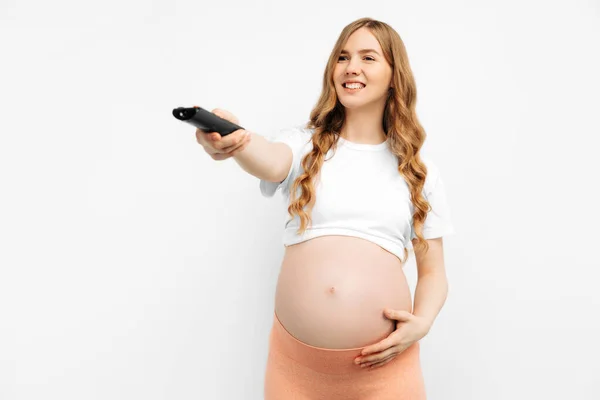 Jovem Grávida Com Controle Remoto Fundo Branco Isolado Mulher Com — Fotografia de Stock