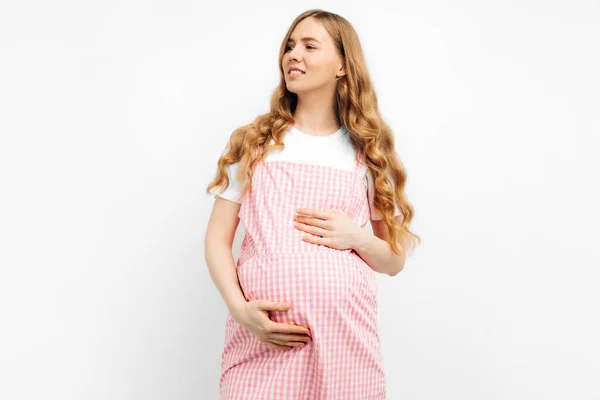 드레스를 임신부 임신을 즐기고 미소를 긴장을 껴안고 배경에 고립된 — 스톡 사진