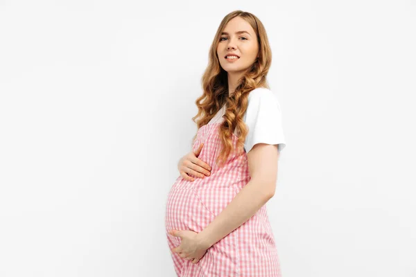 妊娠中の幸せな美しい女性は彼女の腹に触れる 妊娠中のお母さんはお腹を愛撫し 笑顔を閉じています 健康的な妊娠の概念 隔離された白い背景の妊婦 — ストック写真