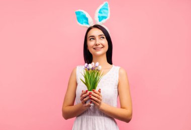 Tavşan kulaklı mutlu kadın yumurta boyalı, geleneksel tatil, stüdyoda pembe arka plan, paskalya havası, Hıristiyan bayramı. Yüksek kalite fotoğraf