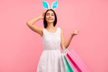 Elinde alışveriş torbalarıyla tavşan kulaklı güzel bir kadın bahar alışverişi, geleneksel bir tatil.