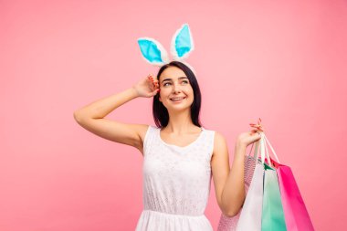 Elinde alışveriş torbalarıyla tavşan kulaklı güzel bir kadın bahar alışverişi, geleneksel bir tatil.