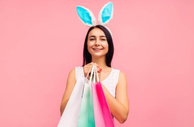 Elinde alışveriş torbalarıyla tavşan kulaklı güzel bir kadın bahar alışverişi, geleneksel bir tatil.