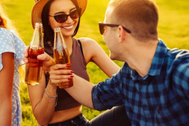 Gençler doğada piknik yaparlar. Genç arkadaşlar rahatlar, pizza yer ve içki içerler. Bir grup genç gün batımında bir yaz parkında çimlerin üzerinde otururken iletişim kuruyor. Arkadaşlar boş zamanlarında rahatlar..