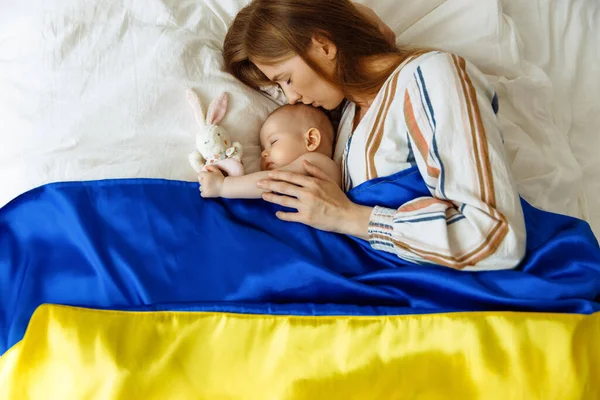 Close Portrait Mother Kissing Her Newborn Baby Sleeping Bed Home lizenzfreie Stockfotos