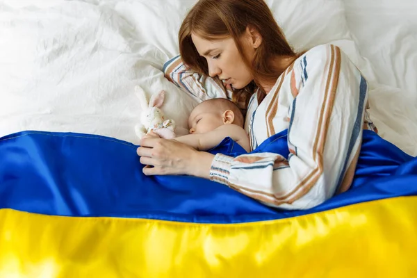 ภาพถ ายใกล ดของแม บทารกแรกเก ดของเธอนอนบนเต ยงท านปกคล วยธงส าและส เหล รูปภาพสต็อก
