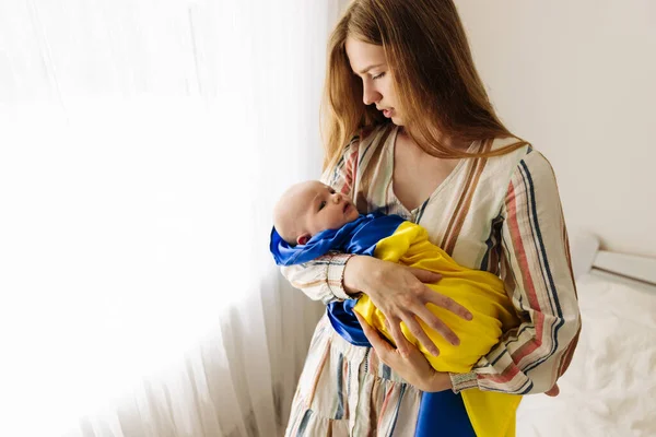 Woman Holds Her Sleeping Little Child Her Arms Wrapped Yellow — ストック写真