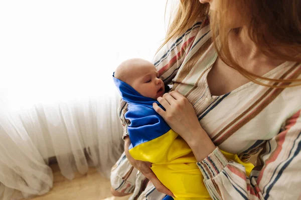 Woman Holds Her Sleeping Little Child Her Arms Wrapped Yellow — Stok Foto