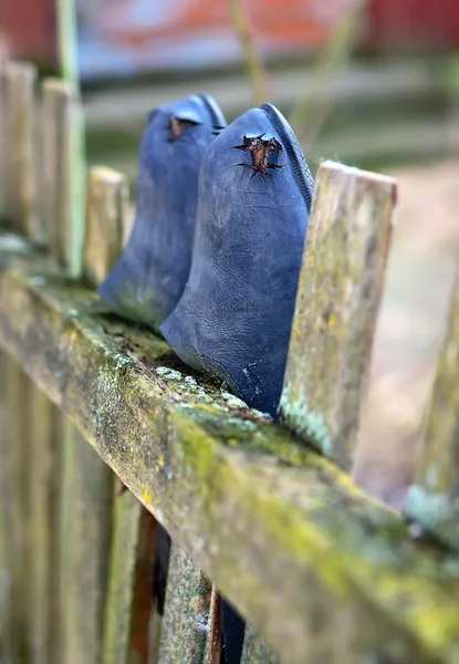 Old galoshes on the fence — Stock Photo, Image