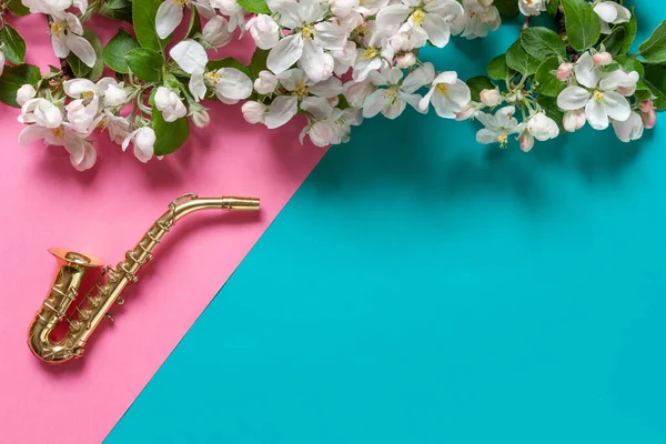 Kleine Gouden Saxofoon Bloeiende Appelboomtakken Bovenaanzicht Close Pastelroze Lichtblauwe Duotone — Stockfoto