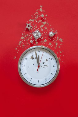 Çağdaş çalar saat ve Noel süslemeleri ile kırmızı zemin üzerinde noel veya yeni yıl kompozisyonu - yıldızlar, konfeti, toplar ve hediye kutuları, üst görünüm, düz yatış