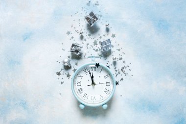 Noel, gökyüzünde yeni yıl kompozisyonu modern alarm saati ve gümüş rengi Noel süslemeleri - yıldızlar, konfeti, toplar ve hediye kutuları, üst manzara, düz yatış