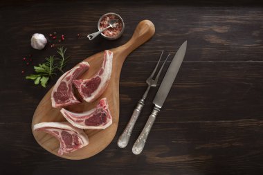 Koyu ahşap zemin üzerinde taze çiğ kuzu eti.