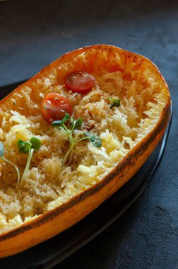 Fresh cooked organic spaghetti squash Cucurbita pepo vegetable on black background with grated cheese