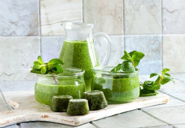 Eritilebilir yeşil smoothie içeceği donmuş sıkıştırılmış meyve küplerinden yapılır. Yaklaş, seçici odaklanma