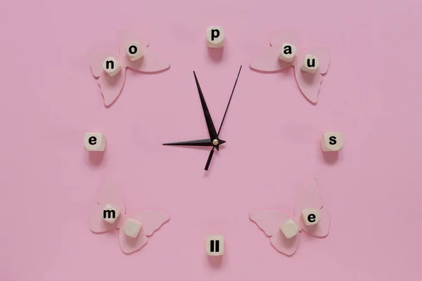 Relógio Despertador Mãos Palavra Menopausa Fundo Rosa Com Borboletas — Fotografia de Stock