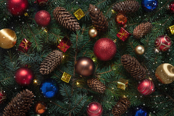 Christmas holiday background with Christmas decorations and fir tree branches with cones. Top view, close up