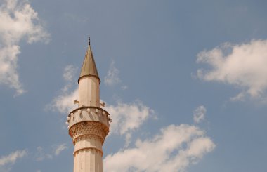 Mavi, bulutlu gökyüzü arka plan üzerinde Minare