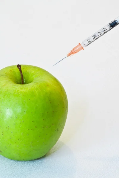 Zelené jablko s injekční stříkačkou — Stock fotografie