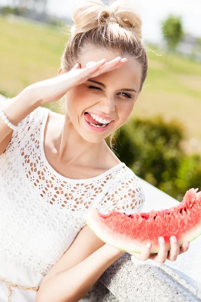 Ragazza in bianco abito estivo mangiare anguria — Foto Stock