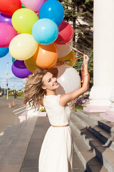 Beautiful lady in retro outfit holding a bunch of balloons — Stock Photo, Image