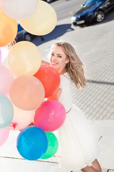 Beautiful lady in retro outfit holding a bunch of balloons — Stock Photo, Image