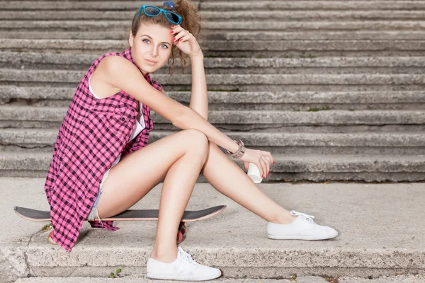 Beautiful sexy lady in jeans shorts with skateboard and to-go cup — Stock Photo, Image